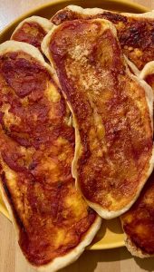 Golden, crispy semolina pizza tongues topped with tomato and oregano