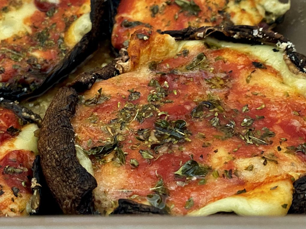 Pizza-style mushrooms with melted mozzarella, tomato passata, anchovies and capers fresh from the oven.
