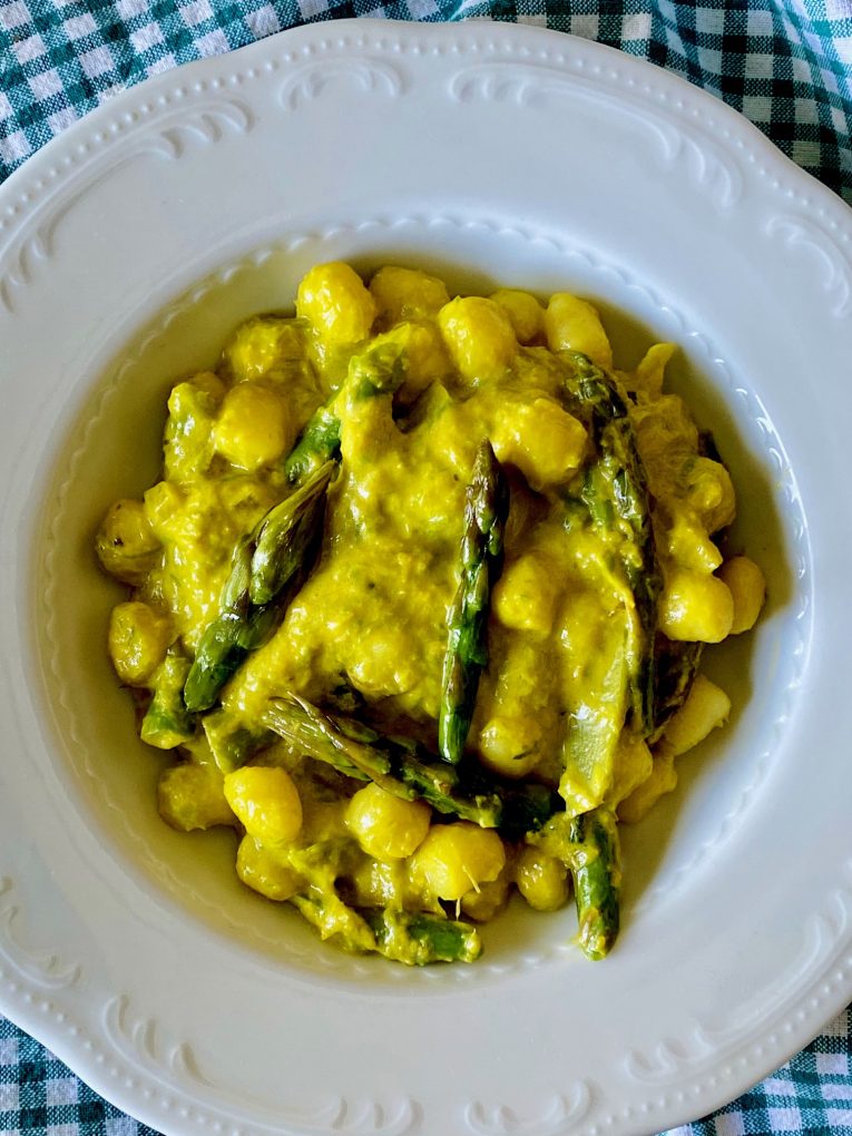 Yellow creamy saffron gnocchi with fresh asparagus