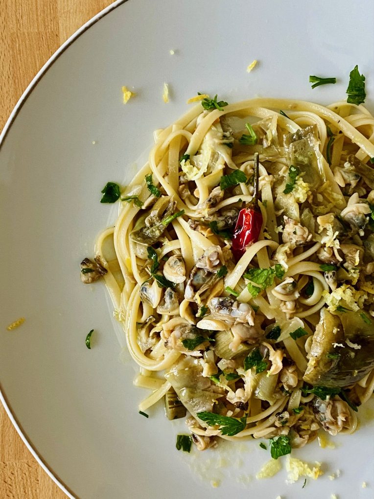 Close-up of linguine with clams and artichokes, finished with fresh parsley